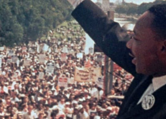 Martin Luther King Jr gives a speech to a large crowd of people