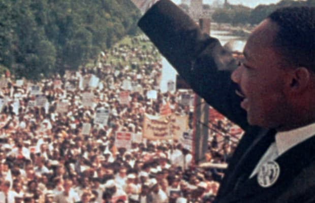 Martin Luther King Jr gives a speech to a large crowd of people
