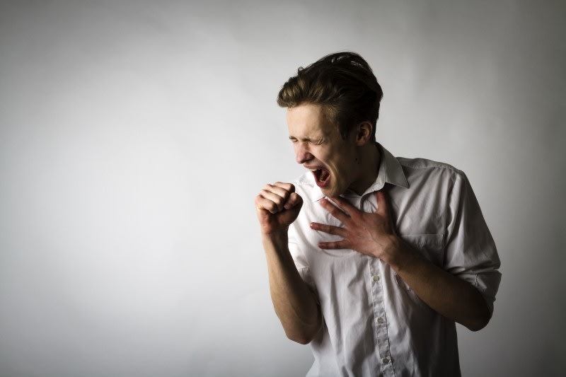 Man coughing because of the flu