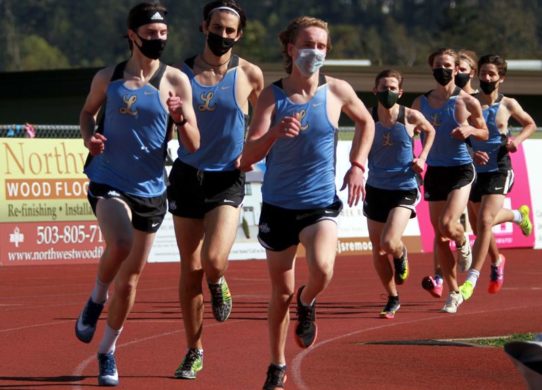 People running on a track with masks on