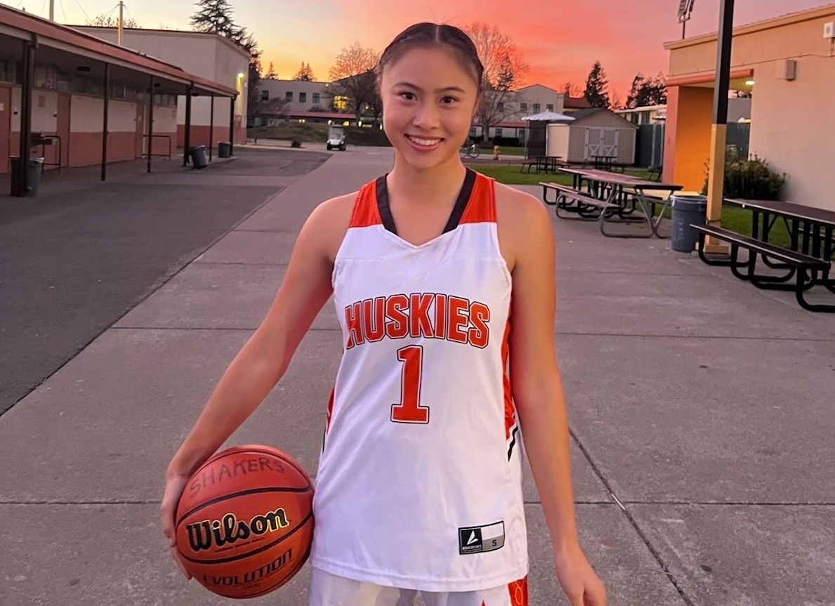 Chloe Dang holding a basketball in uniform