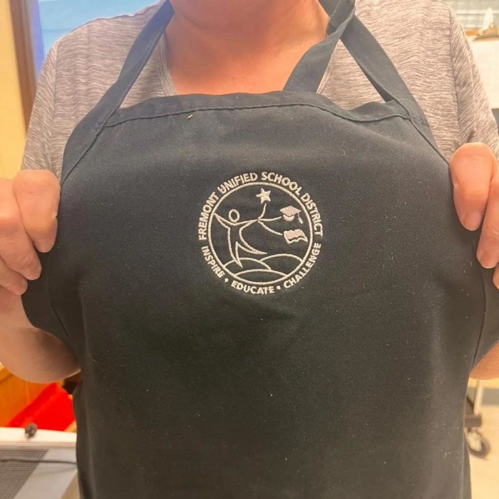 Neck-down picture of Robin Tuck in her FUSD apron.